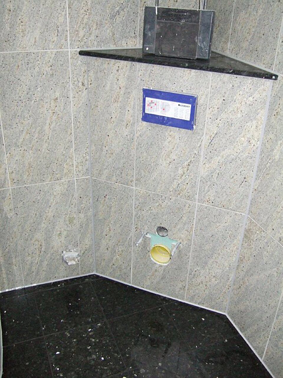 Ein Badezimmer mit schwarzem Boden und weißen Fliesen Scharwat - Fliesen und Naturstein