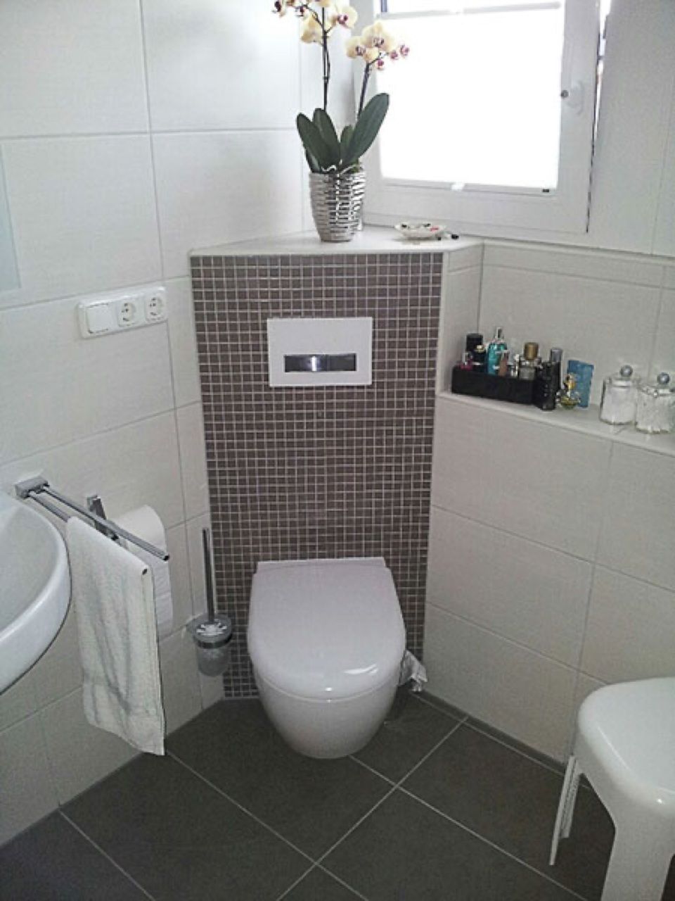 Ein Badezimmer mit Toilette, Waschbecken und Fenster Scharwat - Fliesen und Naturstein