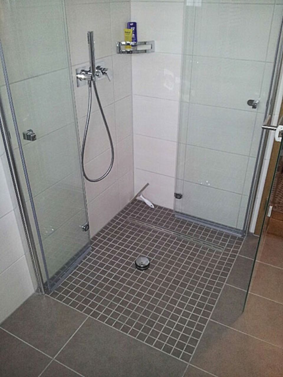 Ein Badezimmer mit ebenerdiger Dusche und gefliestem Boden Scharwat - Fliesen und Naturstein