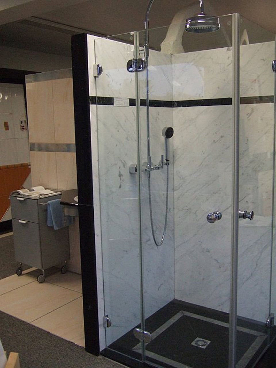 Ein Badezimmer mit ebenerdiger Dusche und Waschbecken, Scharwat - Fliesen und Naturstein