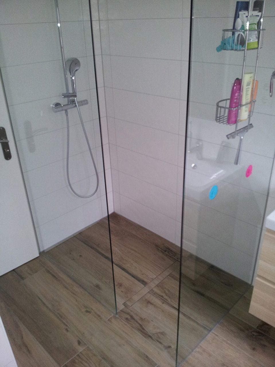 Ein Badezimmer mit ebenerdiger Dusche und Waschbecken Scharwat - Fliesen und Naturstein