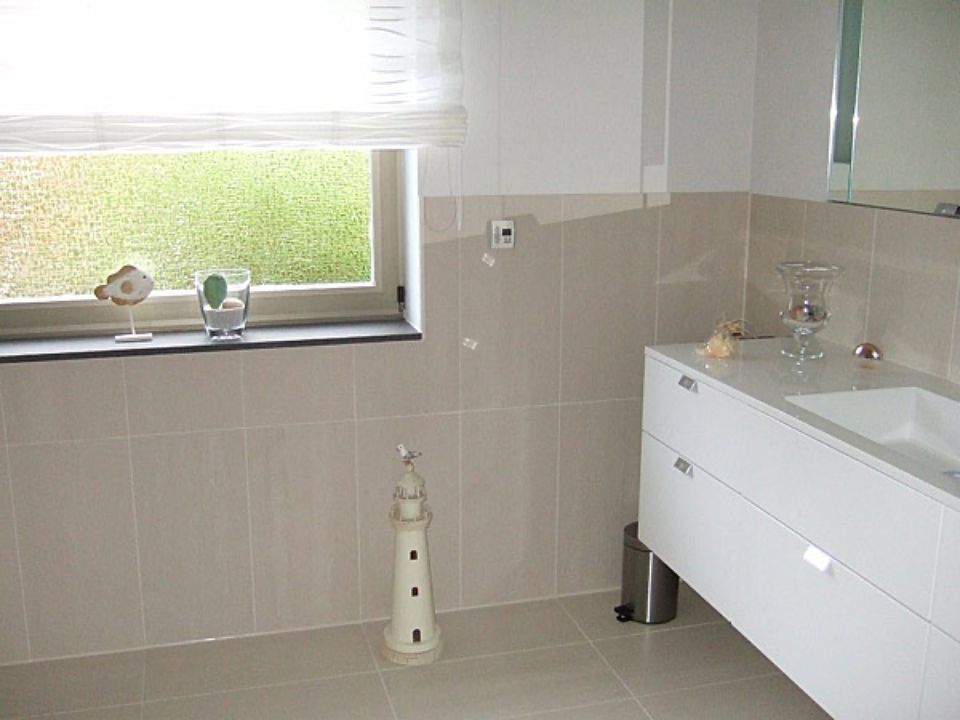 Ein Badezimmer mit Waschbecken und einem Leuchtturm auf dem Boden Scharwat - Fliesen und Naturstein