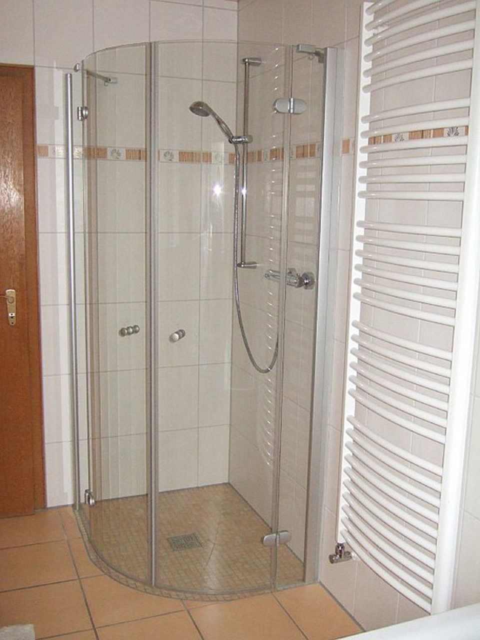 Ein Badezimmer mit Dusche und Handtuchhalter Scharwat - Fliesen und Naturstein