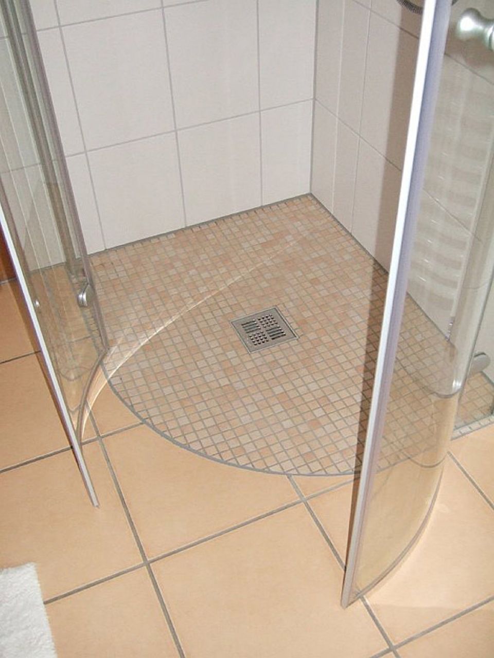 Ein Badezimmer mit ebenerdiger Dusche und gefliestem Boden Scharwat - Fliesen und Naturstein