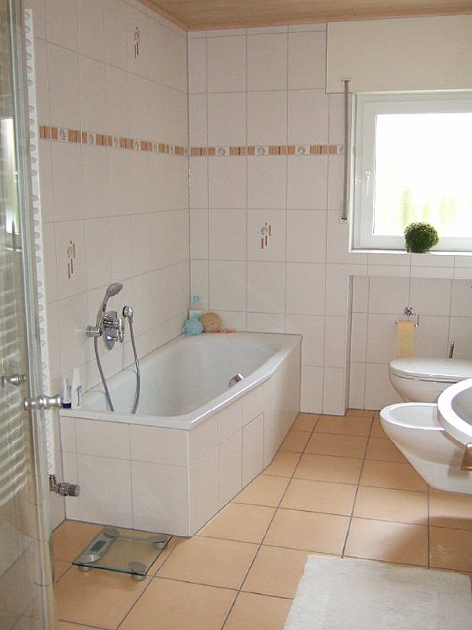 Ein Badezimmer mit Badewanne, Toilette und Waschbecken Scharwat - Fliesen und Naturstein