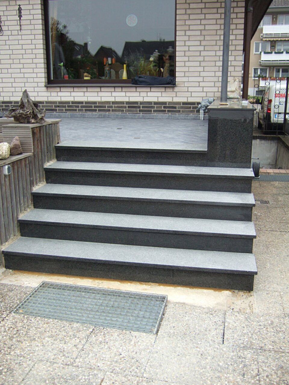 Eine Treppe, die zu einem Backsteingebäude führt Scharwat - Fliesen und Naturstein