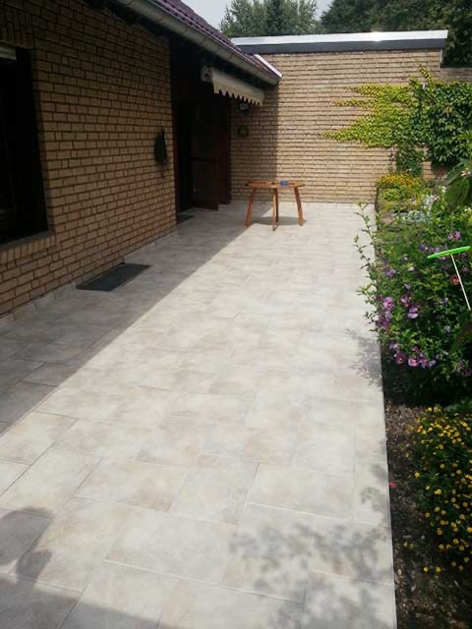 Ein Backsteinhaus mit einer Terrasse davor,  Scharwat - Fliesen und Naturstein