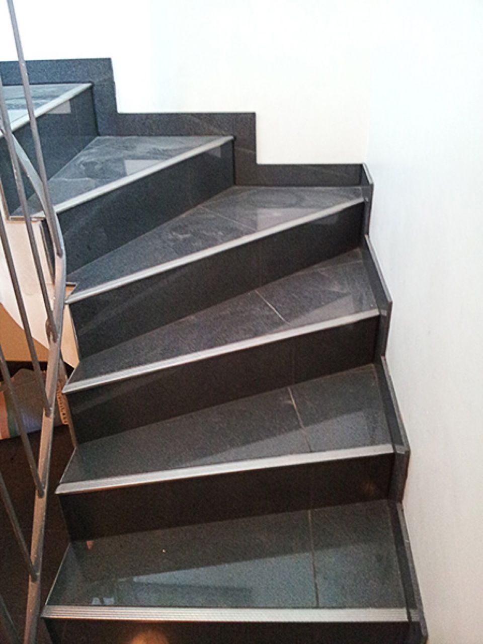 Eine Reihe schwarzer Treppen mit Metallgeländer Scharwat - Fliesen und Naturstein
