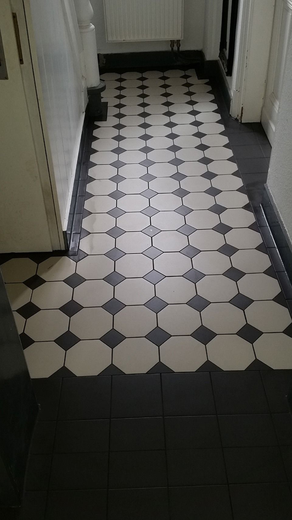Ein Flur mit schwarzen und weißen Fliesen auf dem Boden. Scharwat - Fliesen und Naturstein