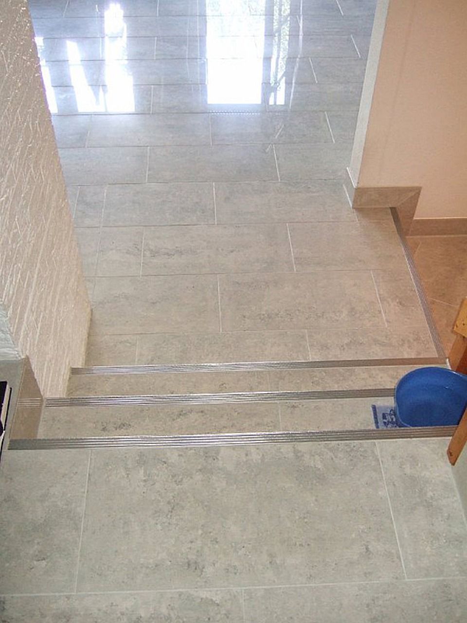 Eine Treppe mit einer blauen Schale auf der untersten Stufe Scharwat - Fliesen und Naturstein