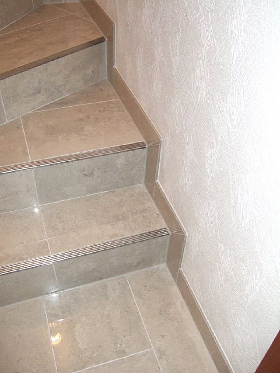 Eine geflieste Treppe mit einer Holzstufe Scharwat - Fliesen und Naturstein