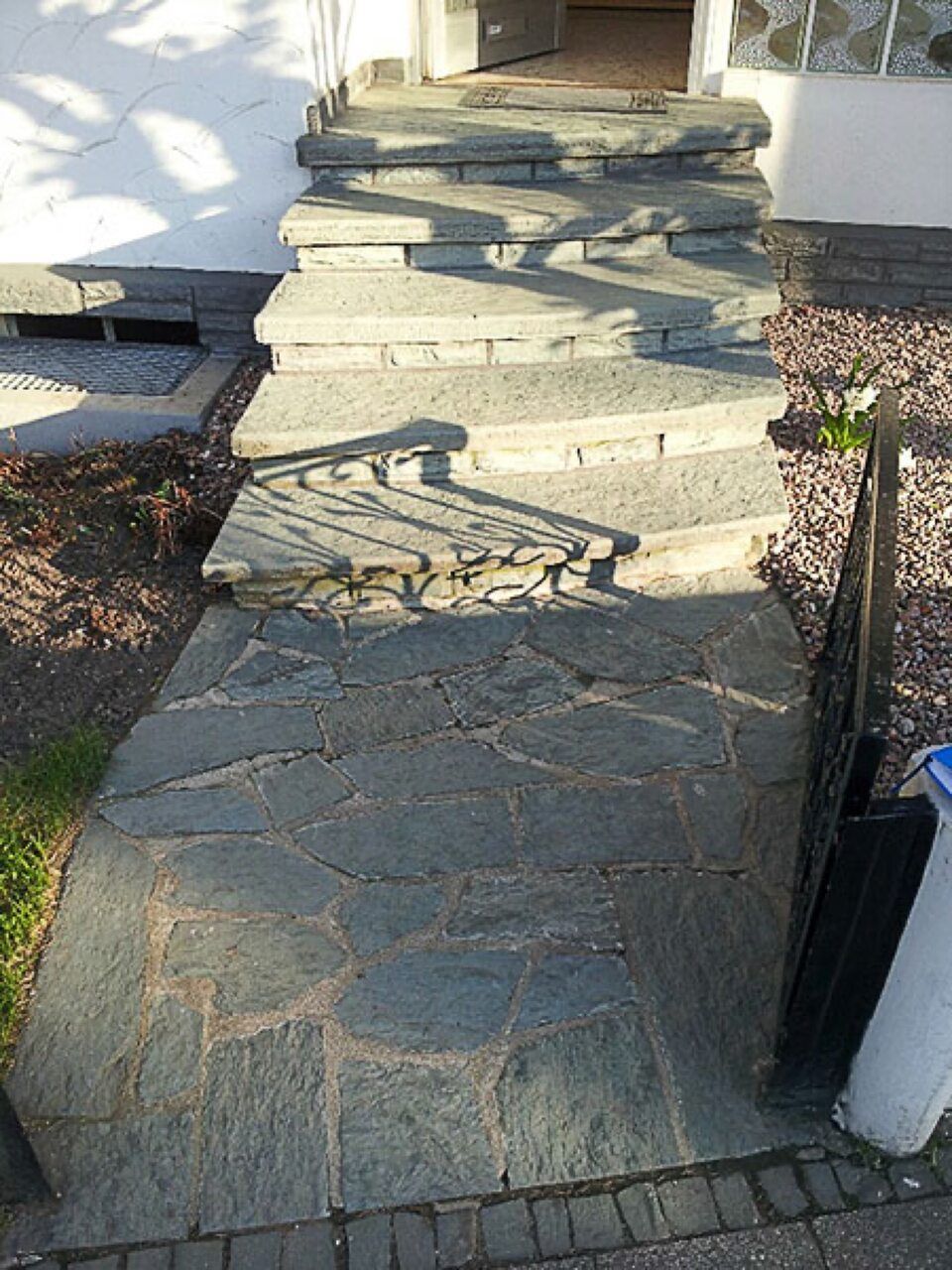 Ein Steinweg, der zu einer Treppe hinaufführt Scharwat - Fliesen und Naturstein