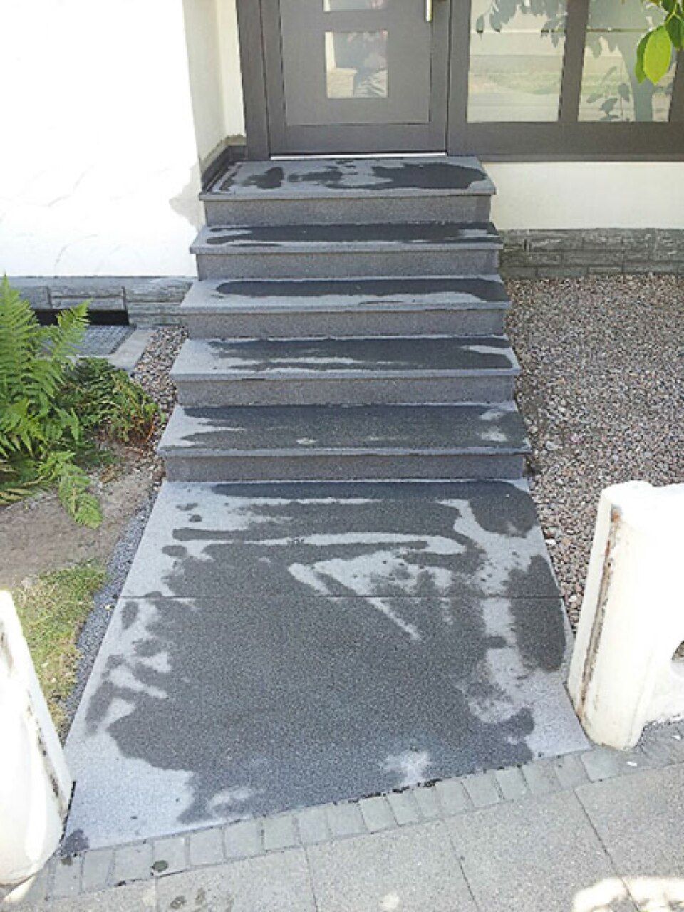 Eine Treppe, die zur Eingangstür eines Hauses führt Scharwat - Fliesen und Naturstein