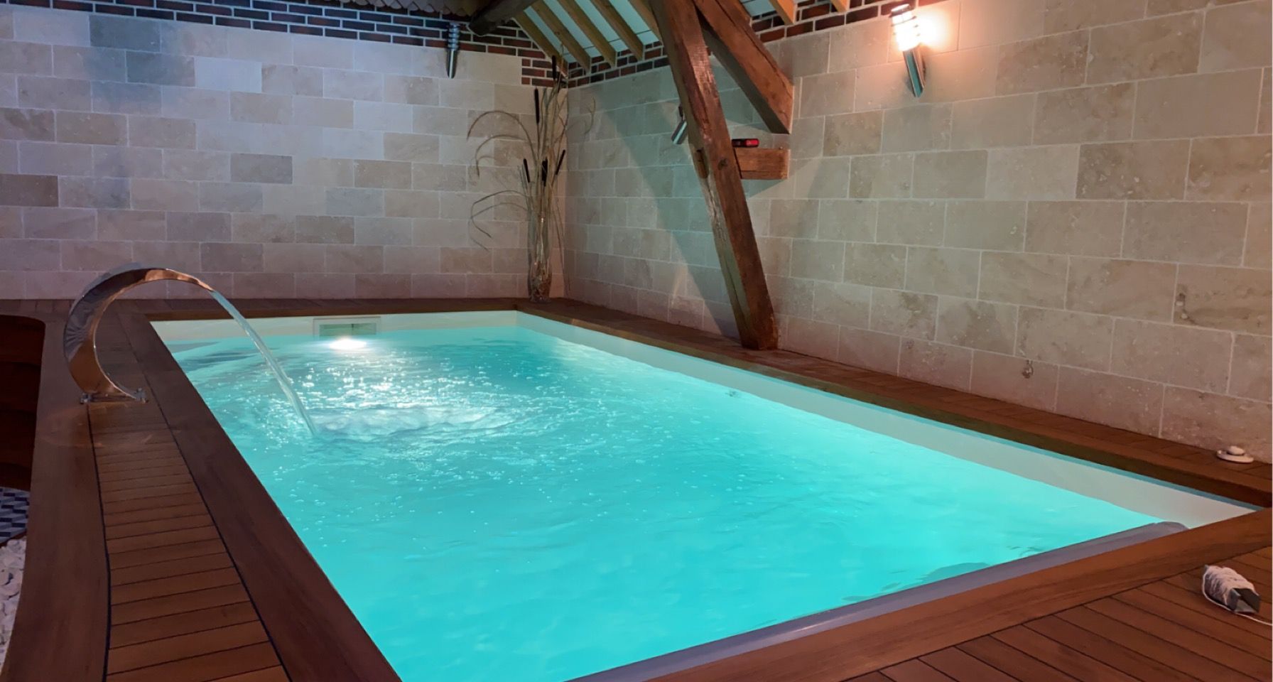 Superbe piscine creusée en intérieur et terrasse en bois