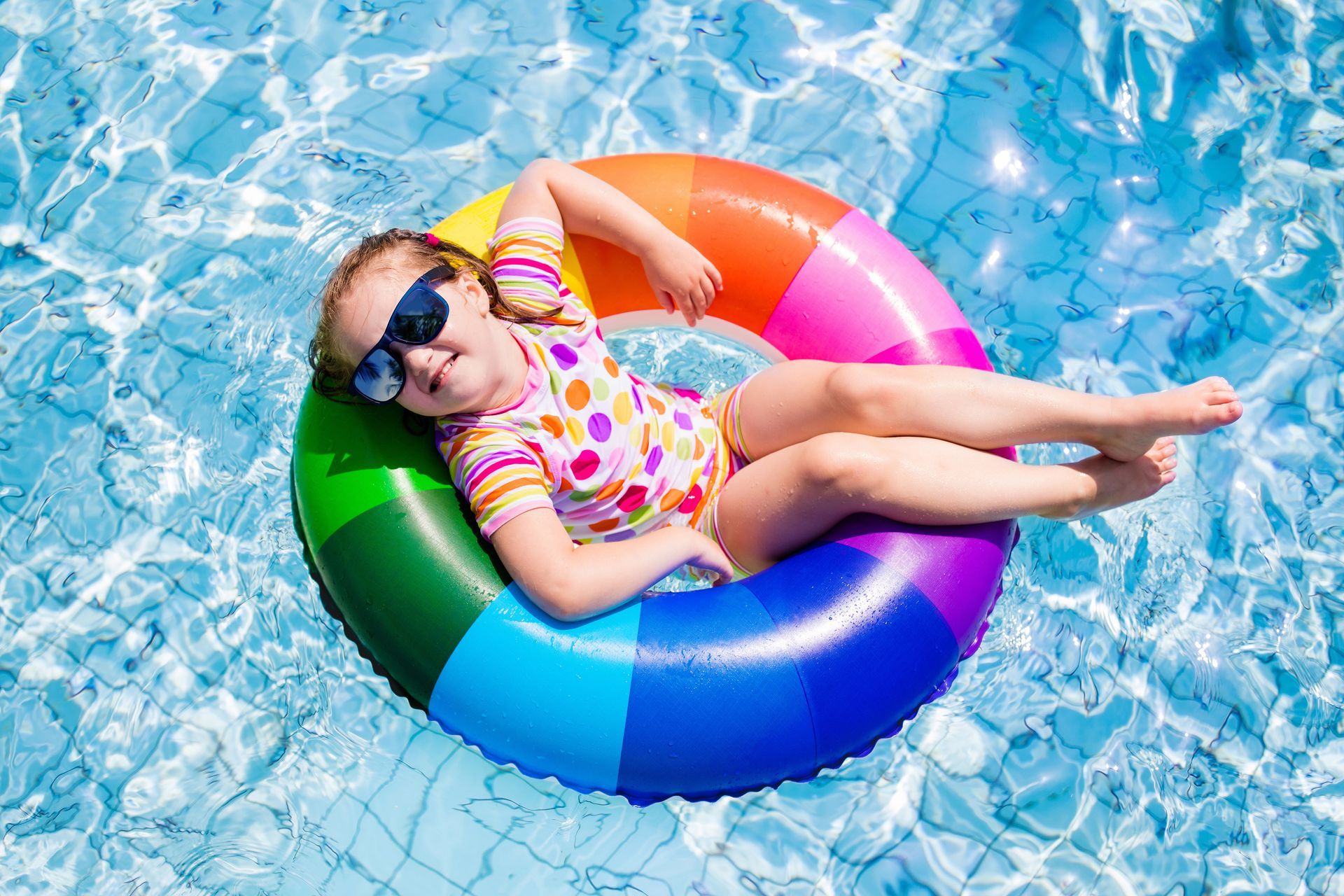 Enfant sur une bouée multicolore dans une piscine