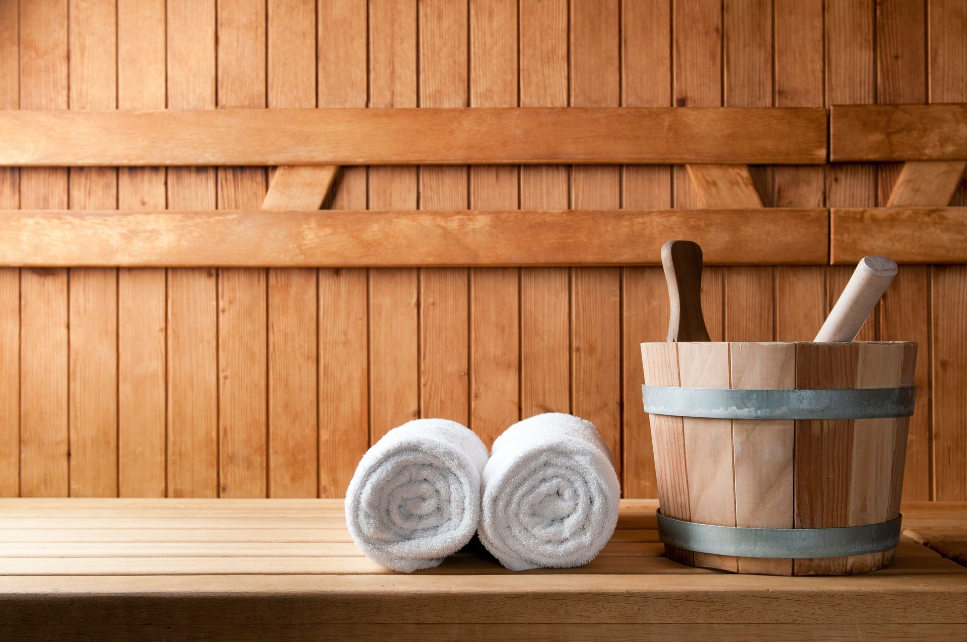 Banc de sauna avec serviettes et seau
