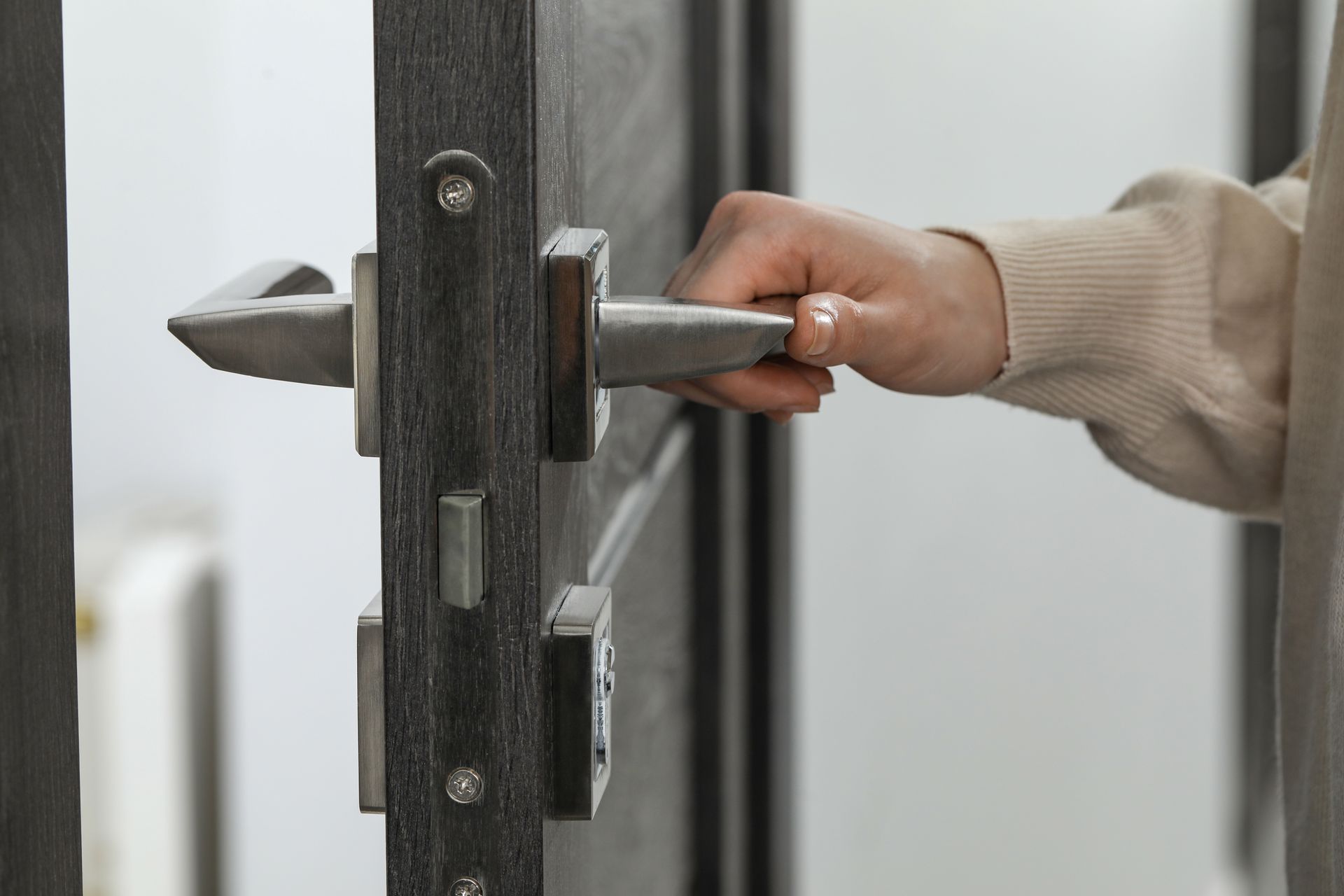 Une main tenant une poignée de porte