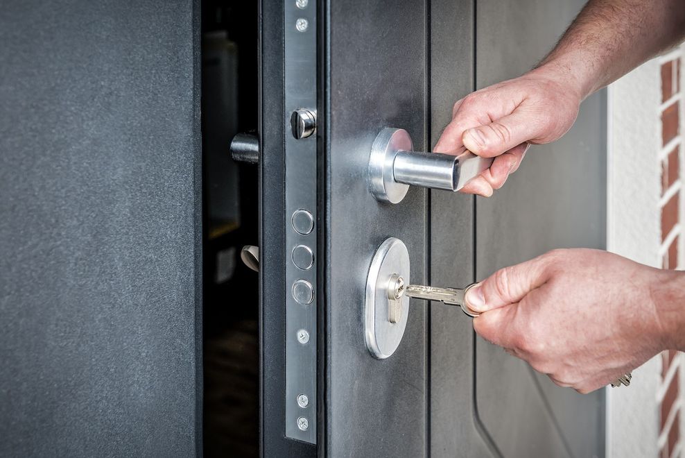 Une personne tient la poignée de porte avec des clés