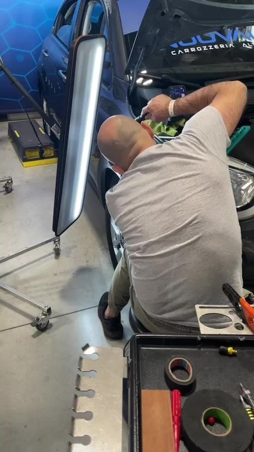 Un hombre está trabajando en un coche en un garaje.