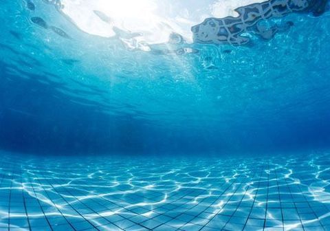 El sol brilla a través del agua en una piscina.
