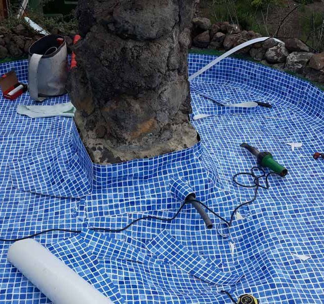 Una piscina en construcción con una gran roca en el medio.