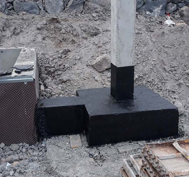 Un poste de hormigón está situado encima de una base de hormigón.