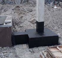 Un poste de hormigón está situado encima de una base de hormigón.