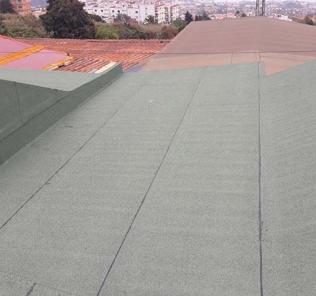 Un techo verde con un techo marrón al fondo.