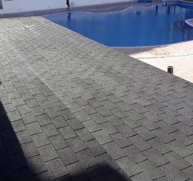 Una azotea con una piscina al fondo.