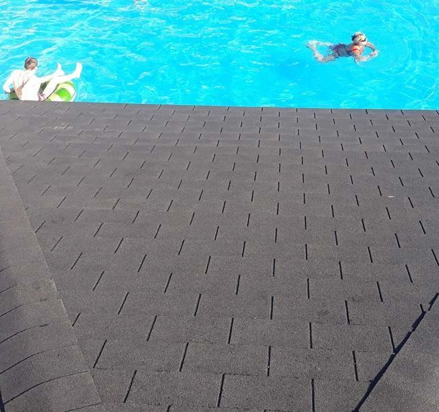 Una pareja de personas están nadando en una piscina