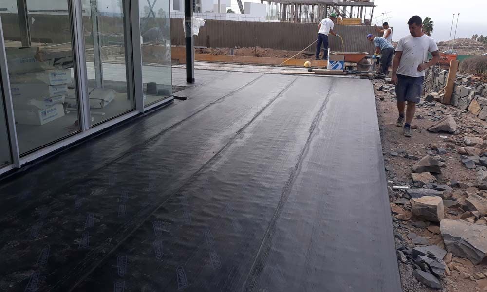 Un grupo de trabajadores de la construcción está trabajando en un piso de concreto.