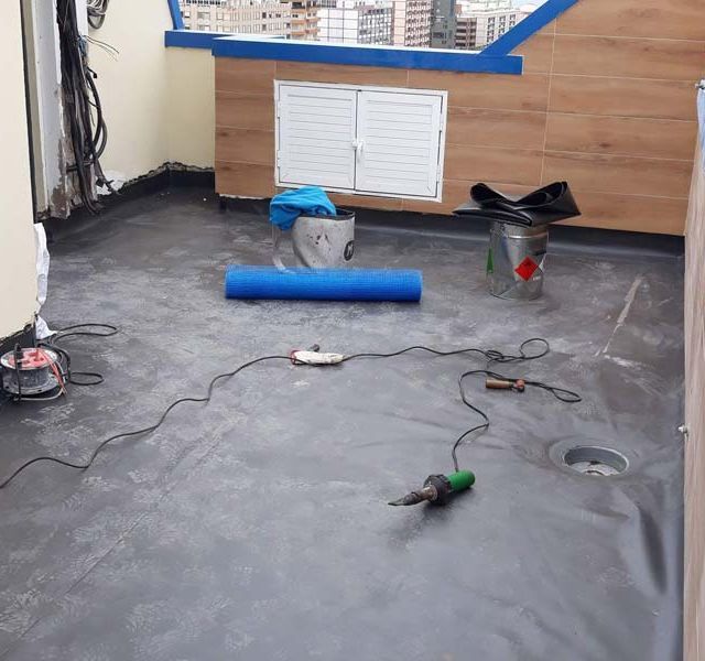 Un rollo de alfombra azul está tendido en el suelo de una habitación.