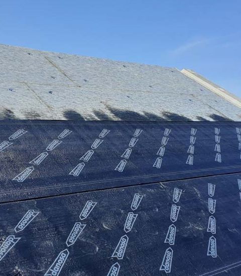 Un primer plano de un tejado con un cielo azul de fondo.