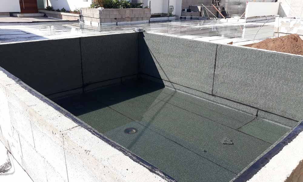 Se está construyendo una gran piscina en el patio trasero de una casa.
