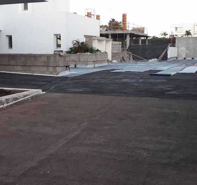 Un sitio de construcción con un edificio blanco al fondo