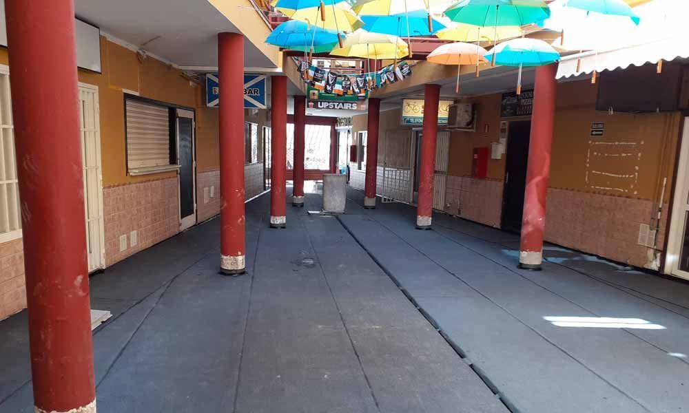 Un pasillo vacío con paraguas colgando del techo.