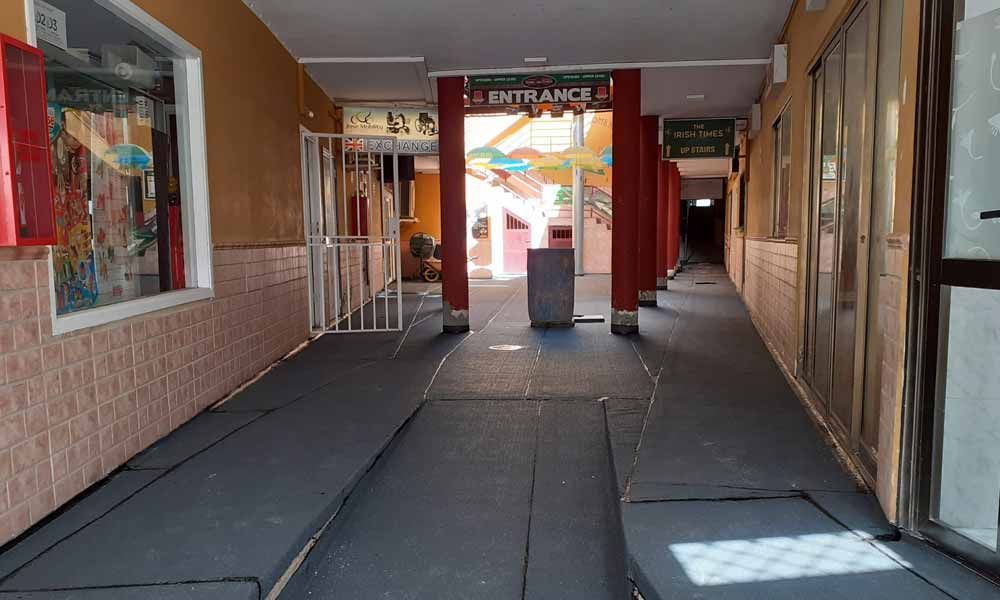 Un pasillo largo con una rampa que conduce a la entrada de un edificio.