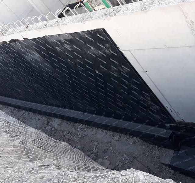 Se está construyendo una valla encima de un muro de hormigón.