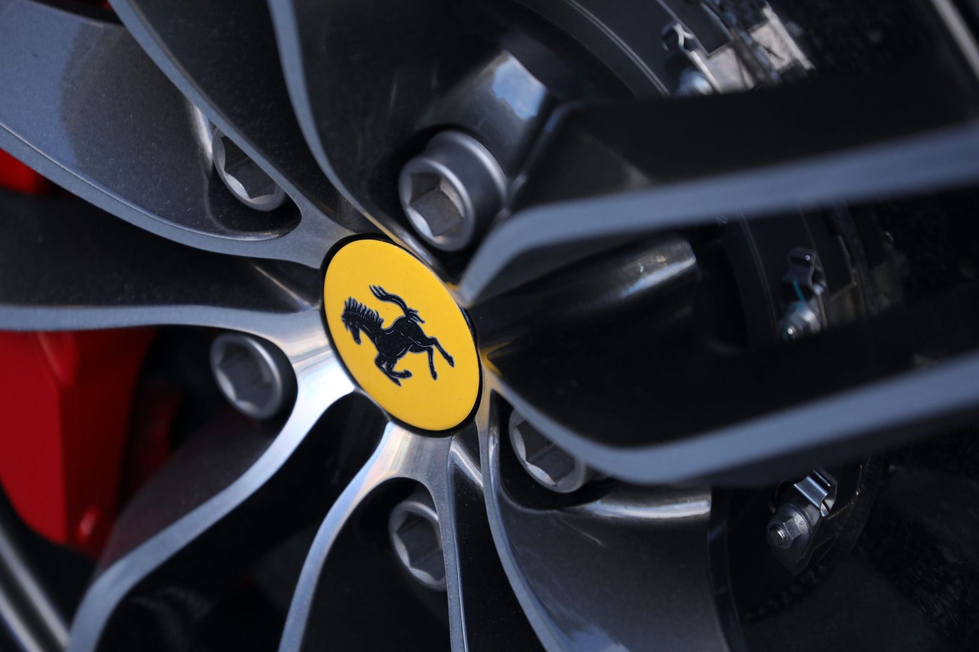 Primer plano de una llanta de Ferrari con el emblema del caballo rampante amarillo.