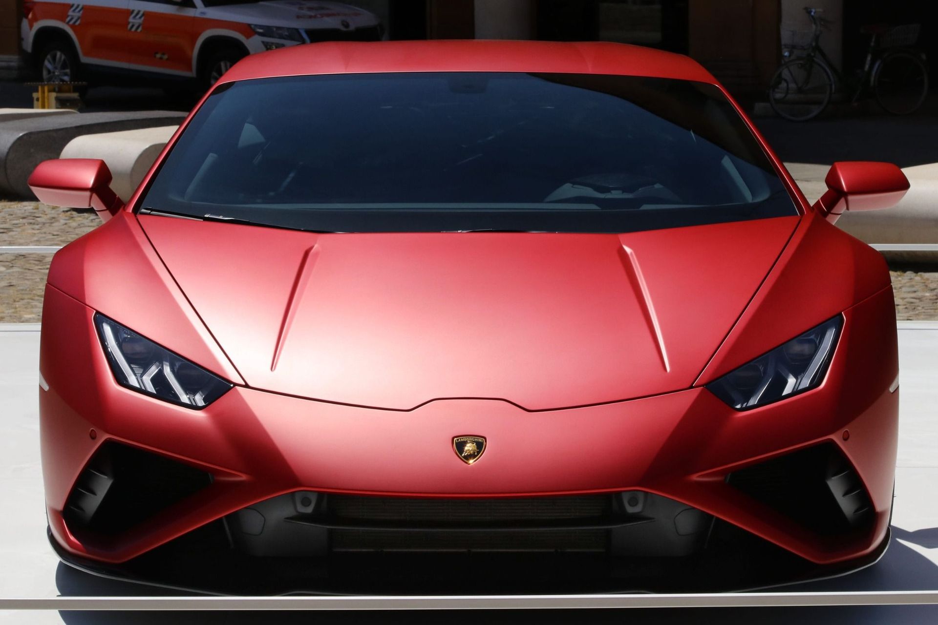 Vista frontal de un deportivo Lamborghini rojo con faros afilados y carrocería roja.