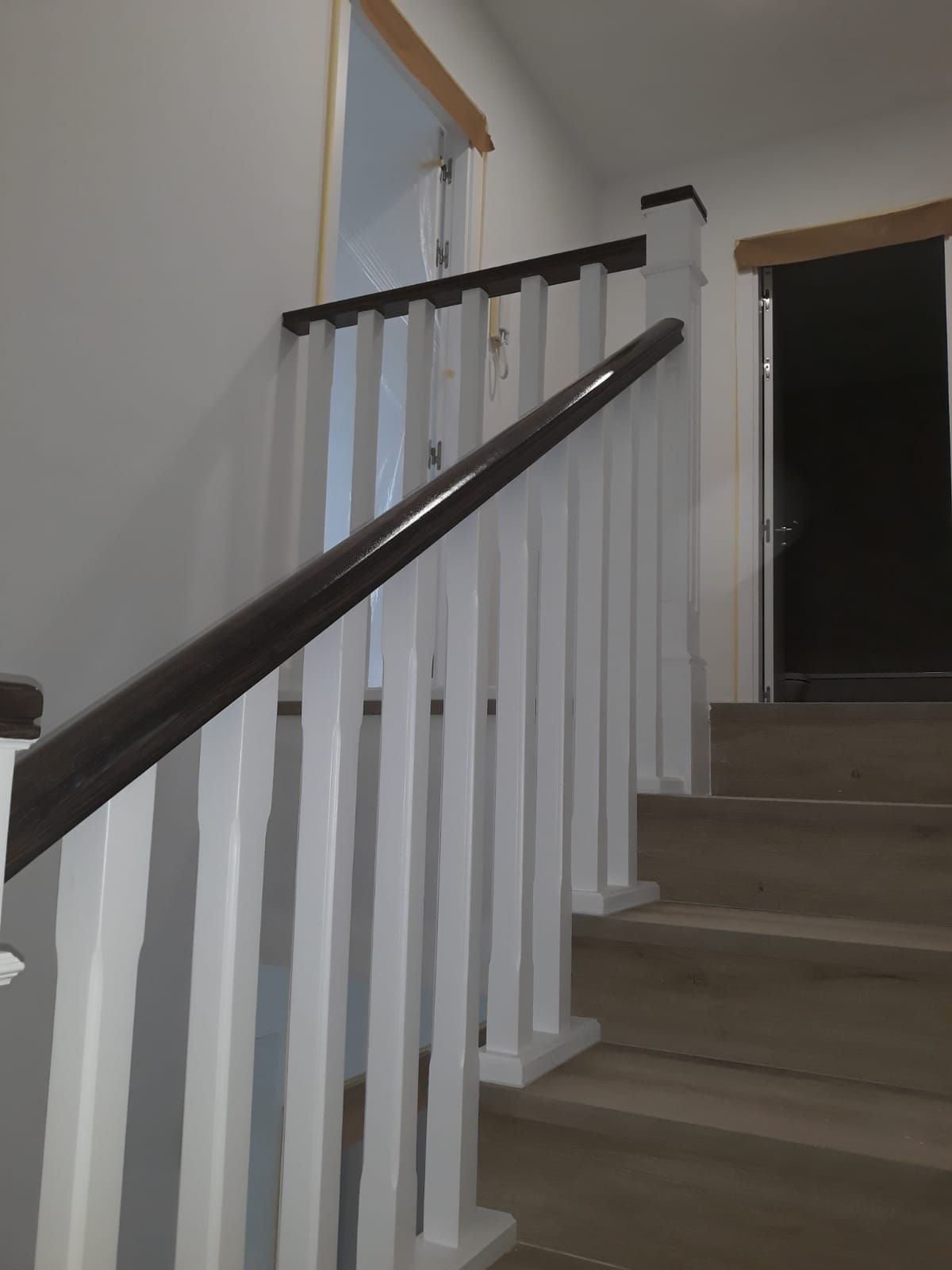 Una escalera con barandilla blanca y pasamanos de madera