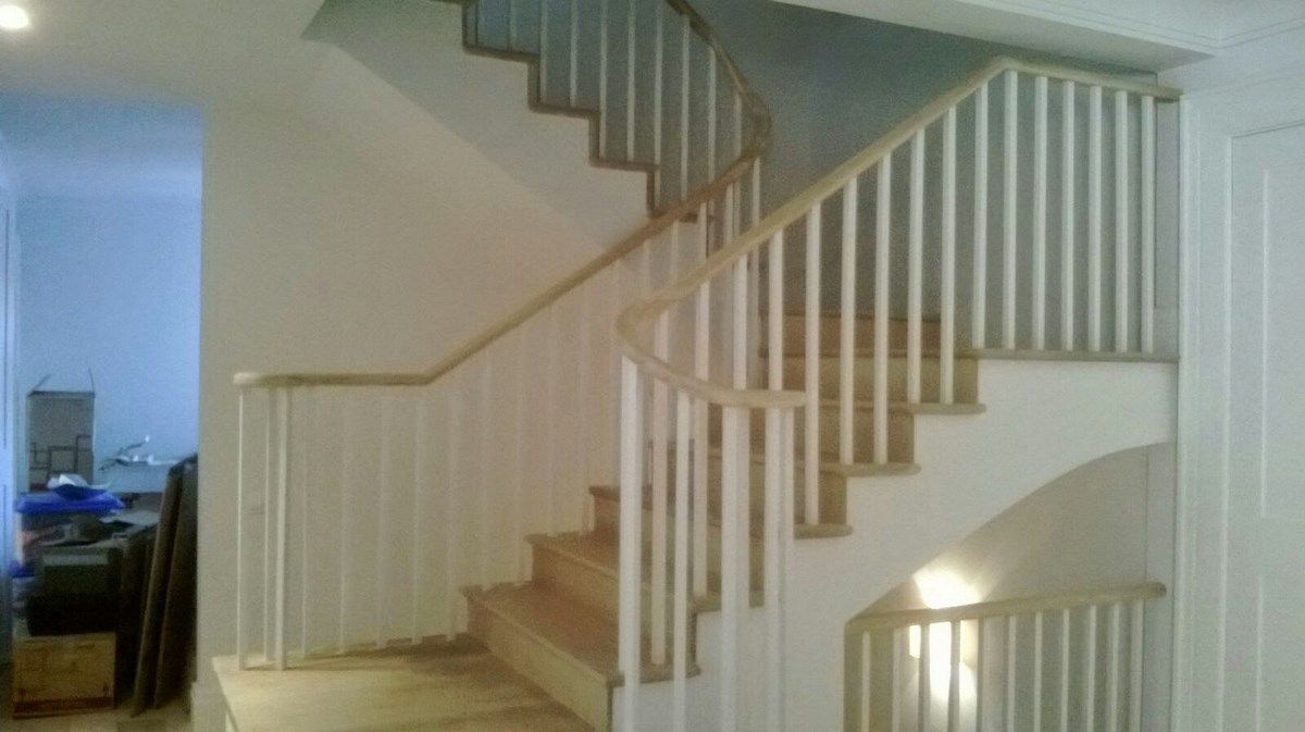 Una escalera con barandilla blanca en una casa.