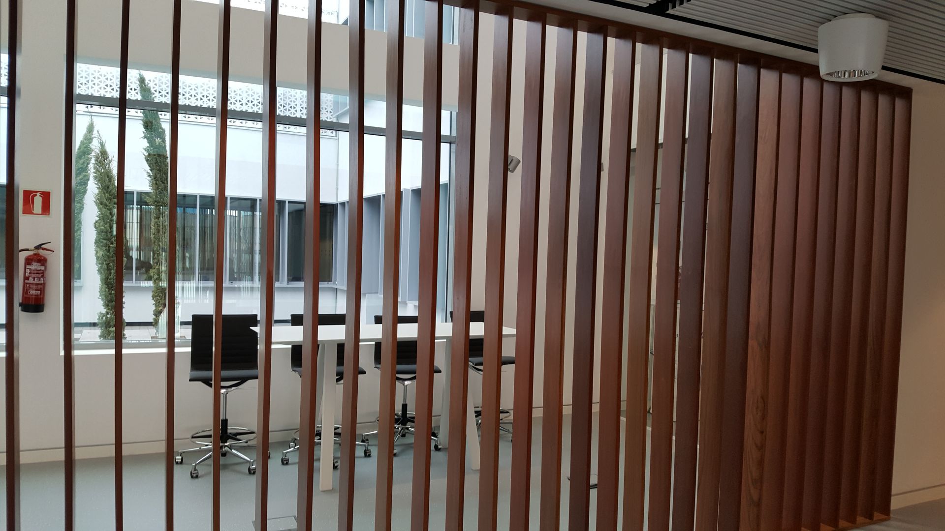 Una habitación con un divisor de madera y un extintor de incendios en la pared.