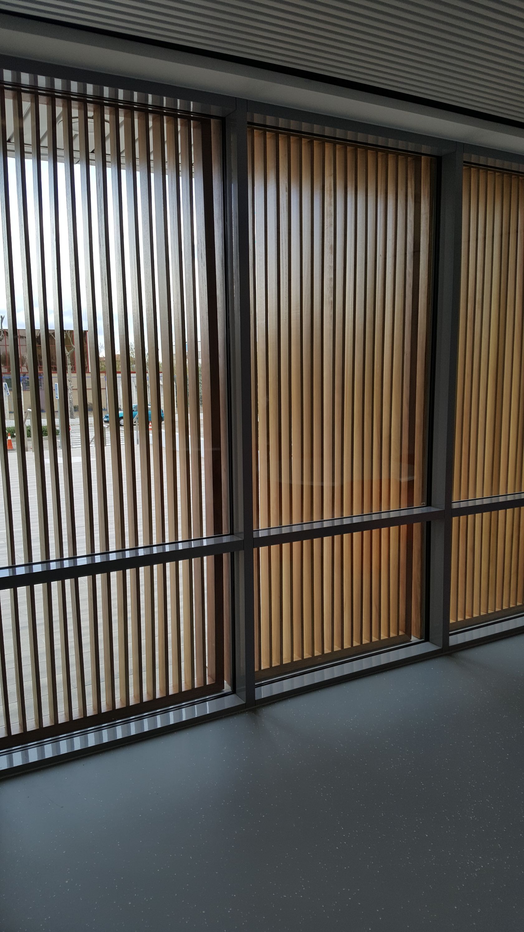 Una habitación con muchas ventanas y persianas de madera.