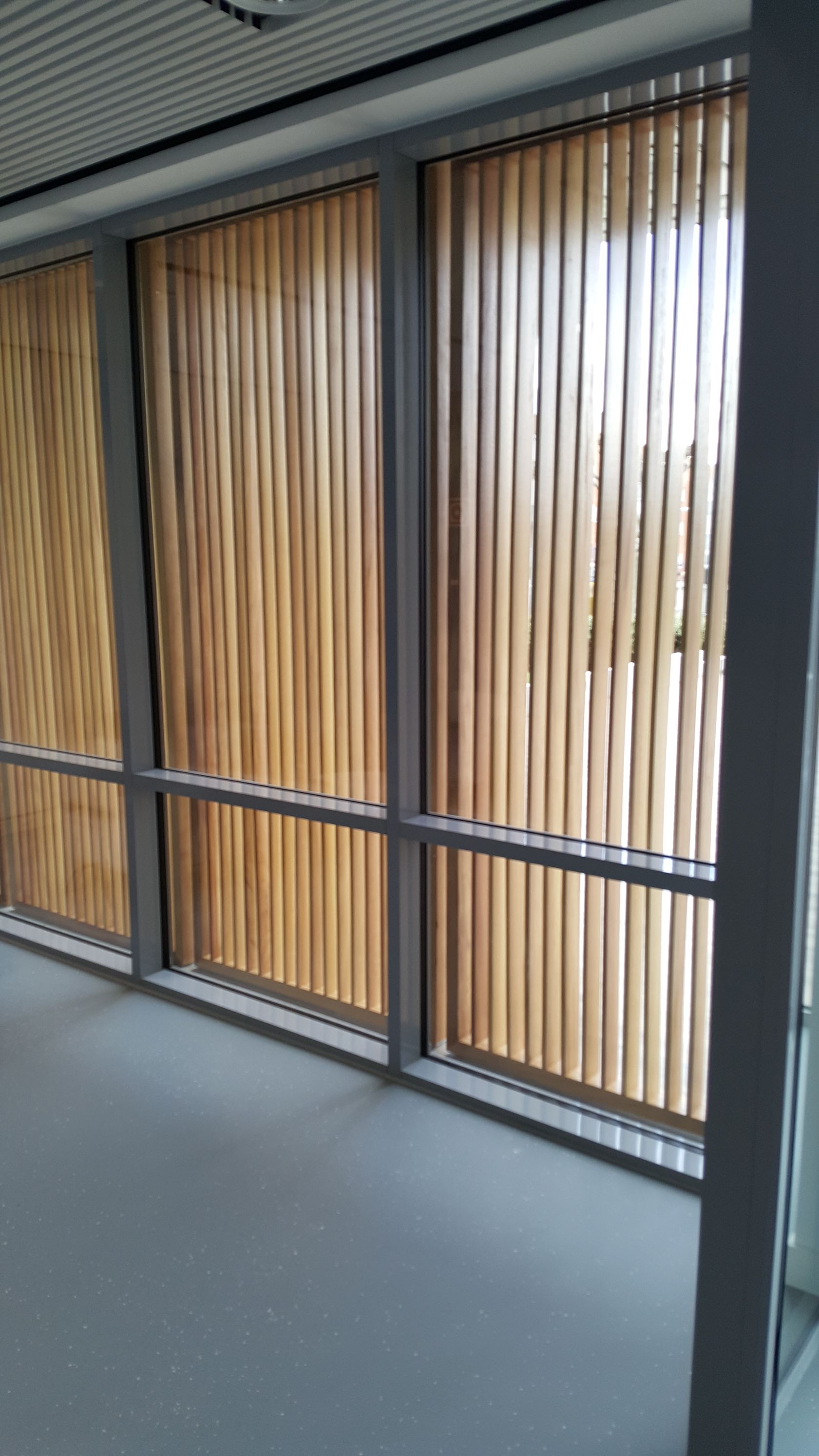 Una habitación con muchas ventanas y persianas de madera.