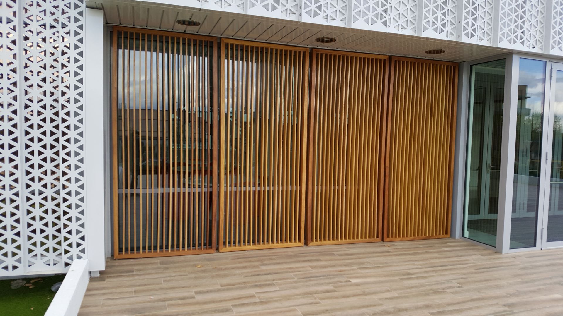 Una valla de madera se encuentra delante de un edificio con muchas ventanas.