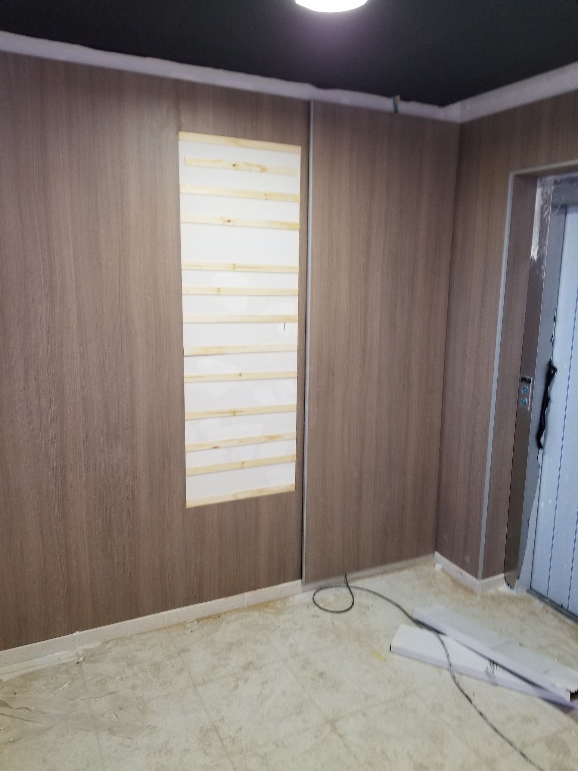 Una habitación con paneles de madera y una ventana.