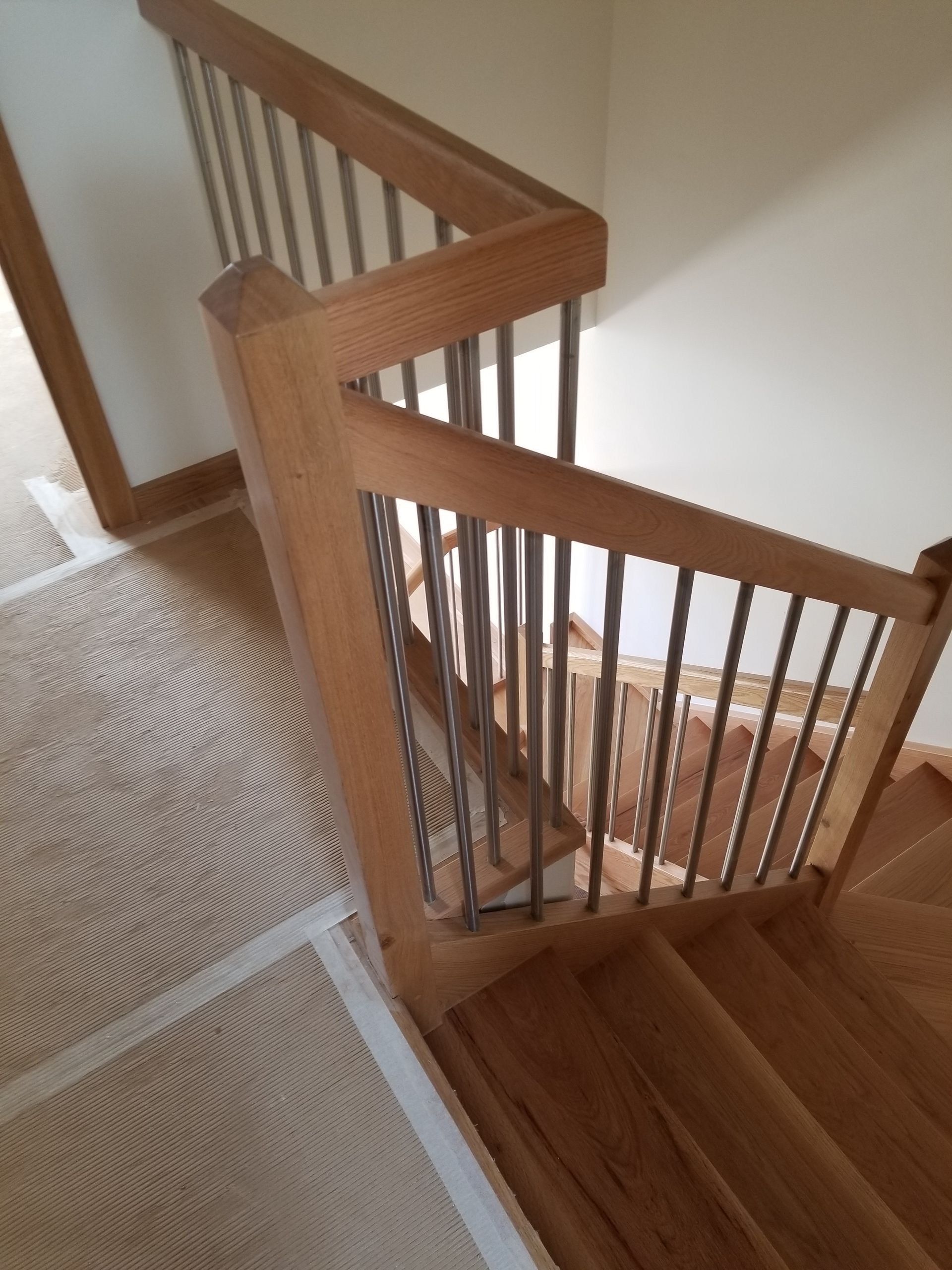 Una escalera de madera con barandilla de metal en una casa.