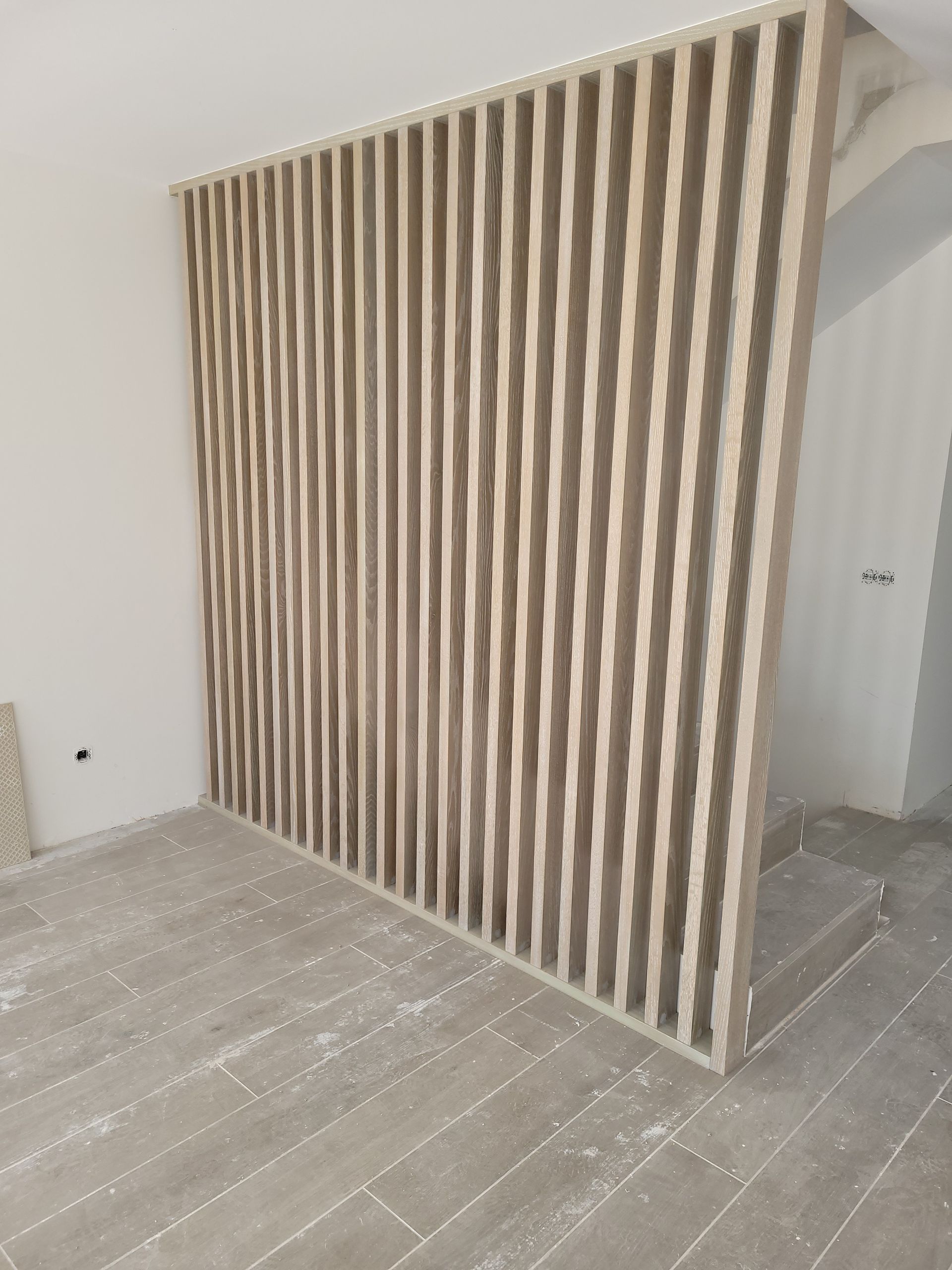 Hay una pared de madera en el medio de una habitación.