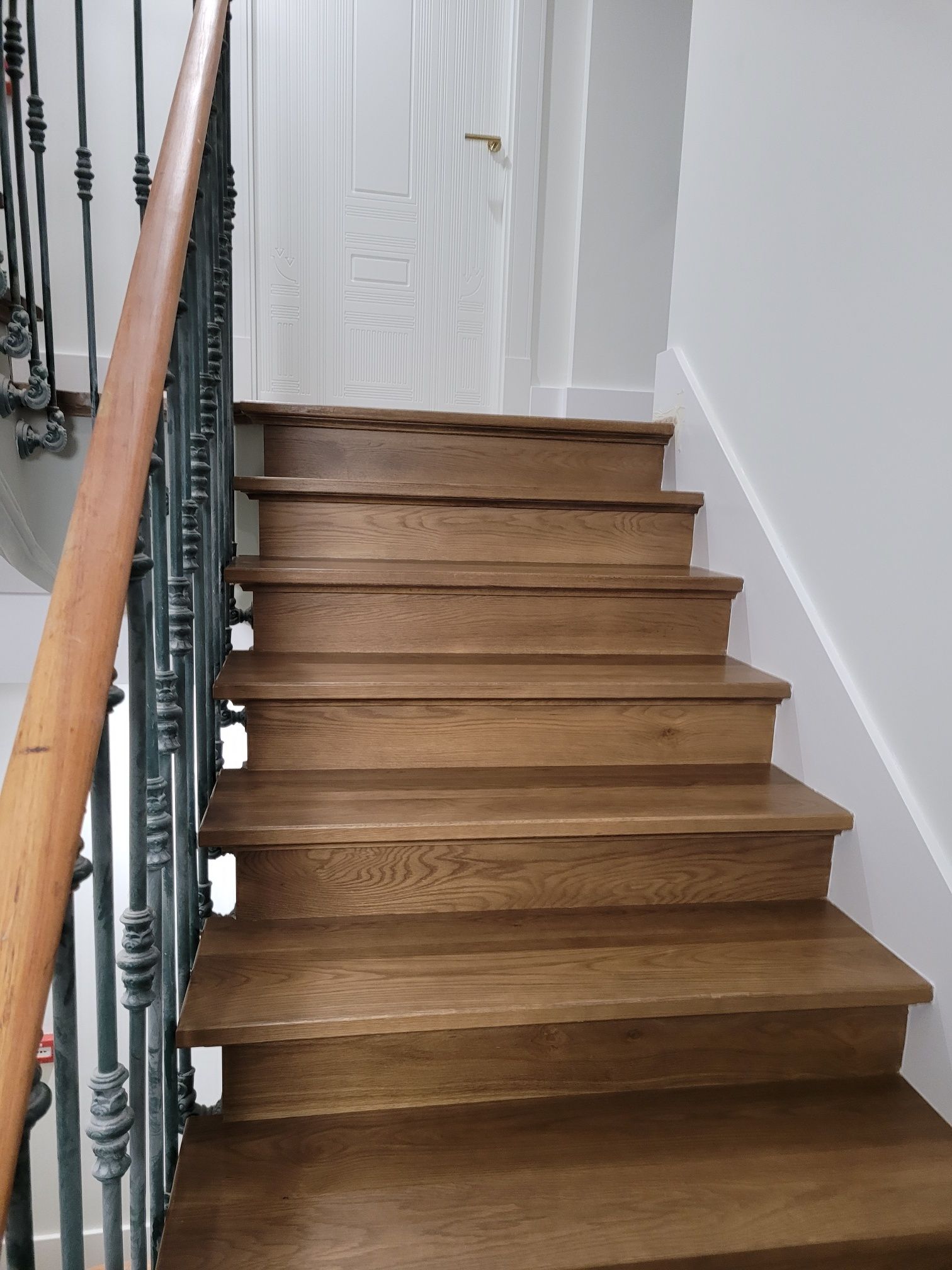 Una escalera de madera con barandilla de metal en una casa.
